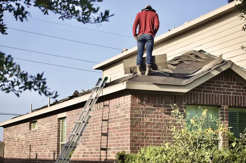 Professional roofer working on a residential roof in Elbert
